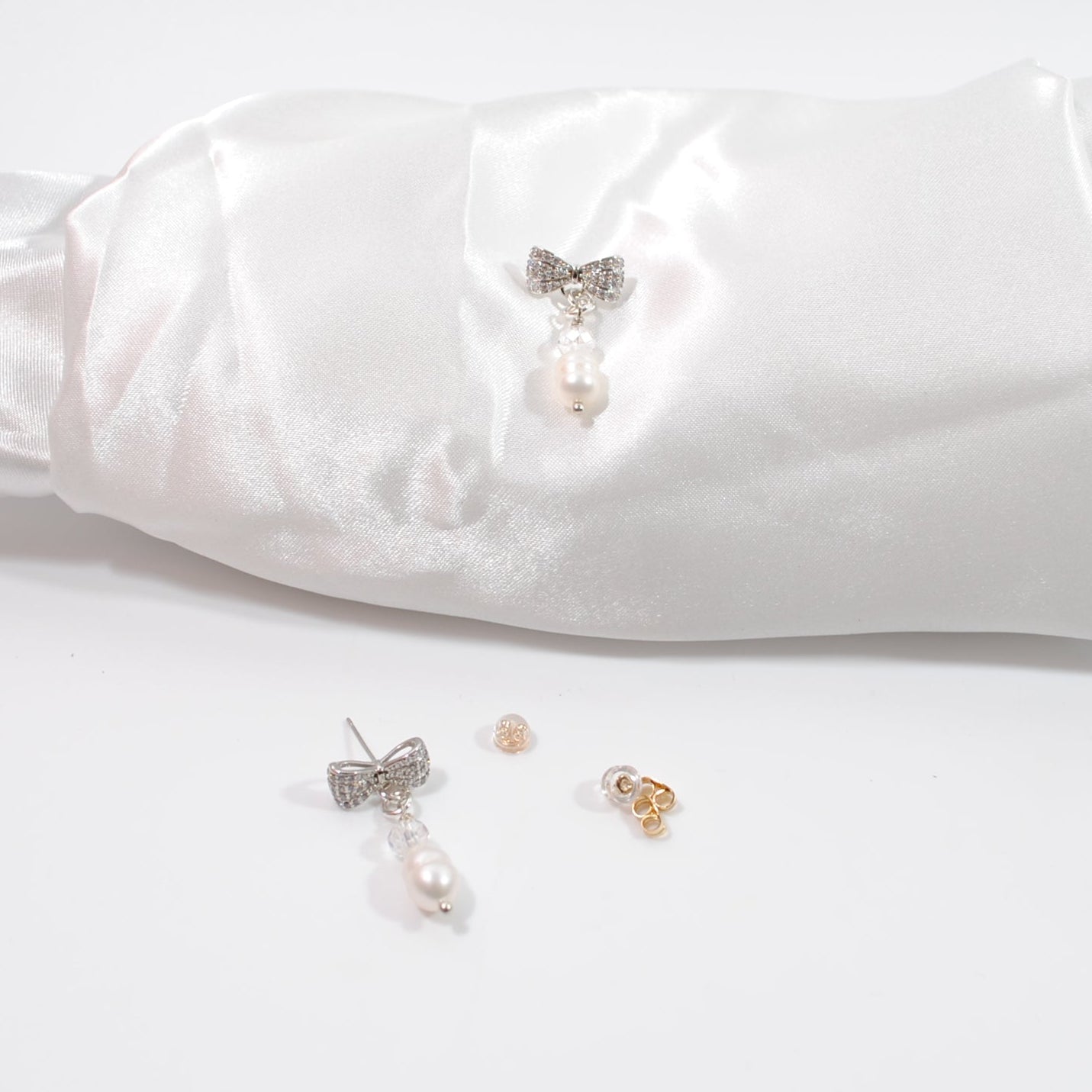 Eleganta Bow Pearls Silver Örhängen i silver med strass fylld rosett, äkta sötvattenpärla och bergkristall. Handgjorda i Sverige. Limited edition. äkta svensk design