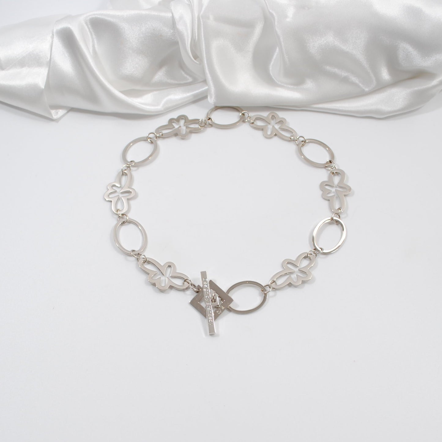 ett kort halsband i silver med cirklar och blommor egendesignat design by brandeby