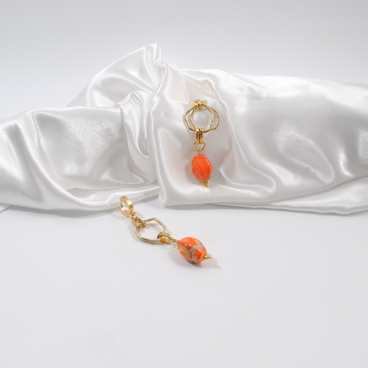 lyxiga örhänge i en längre modell guldringar orange ädelsten imperial jasper design by brandeby