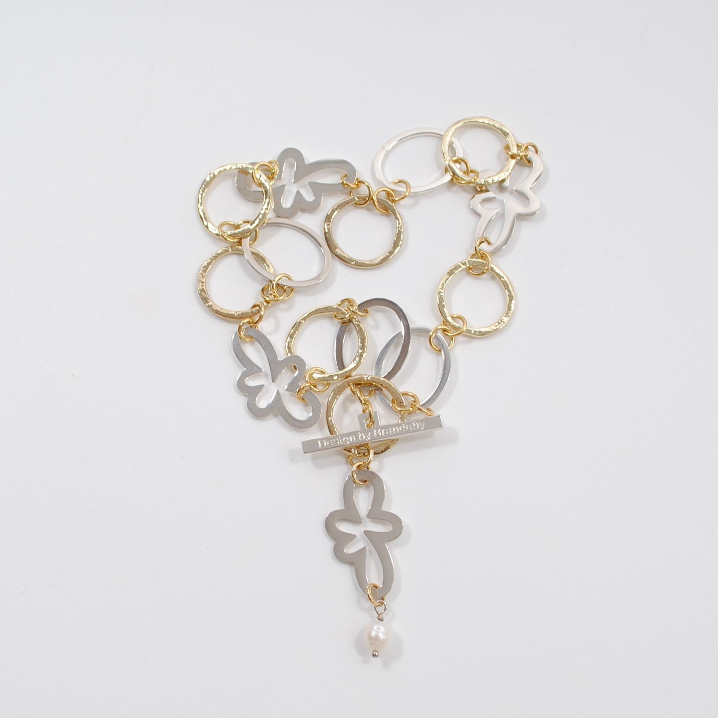 designat svenskt hantverk kort halsband med guldringar och silverblommor design by brandeby