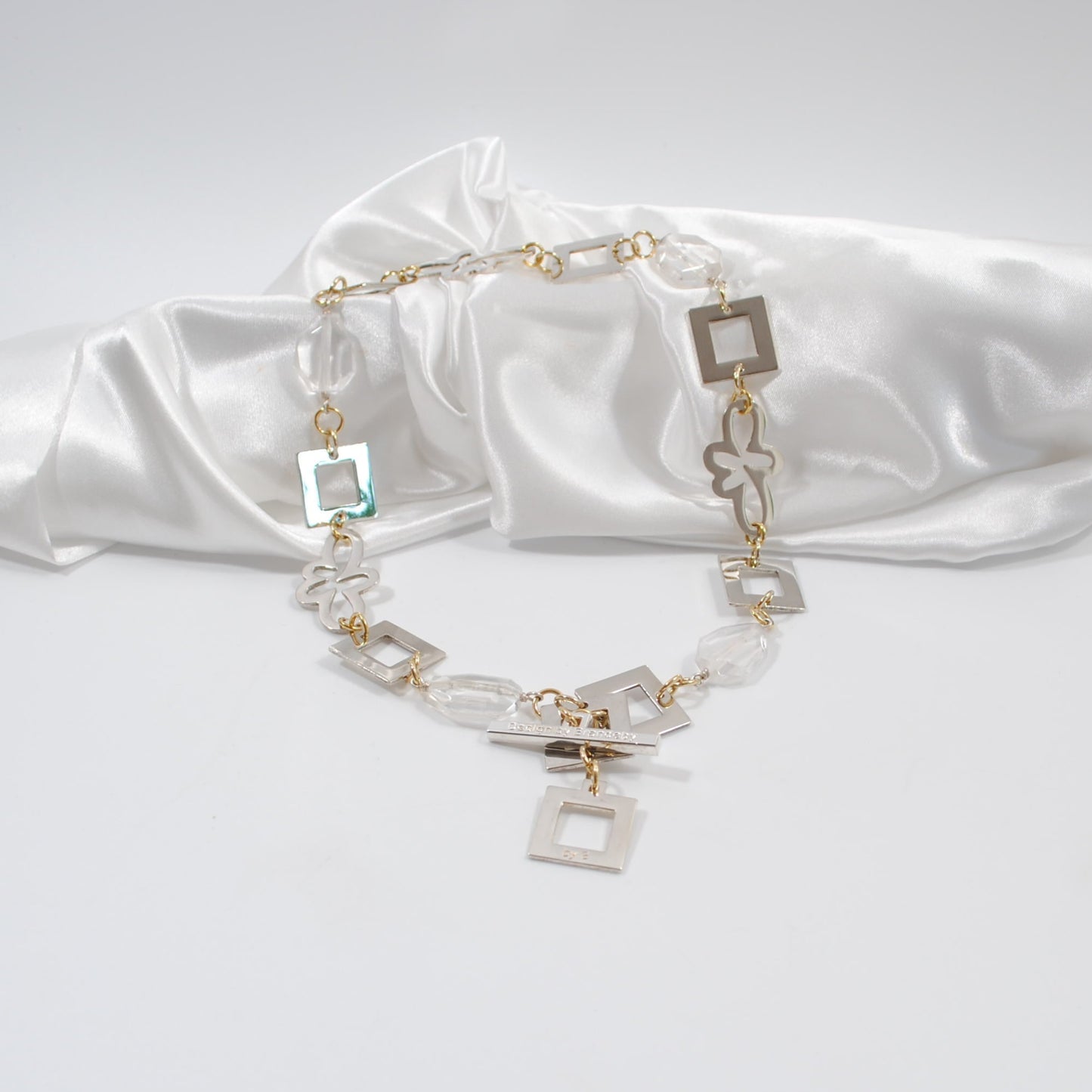 silver blommor och fyrkanter i ett kort halsband med bergkristall äkta ädelsten design by brandeby