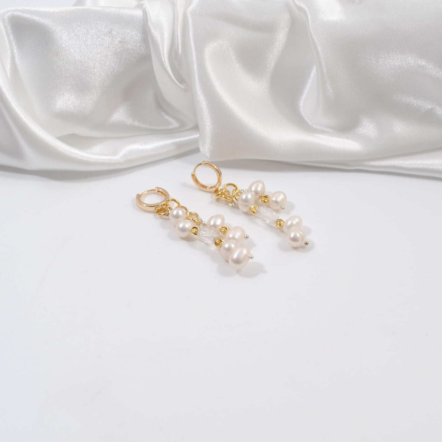 örhängen med vita sötvattenspärlor bergkristall guld detaljer 18 karats guld creoler ringar design by brandeby