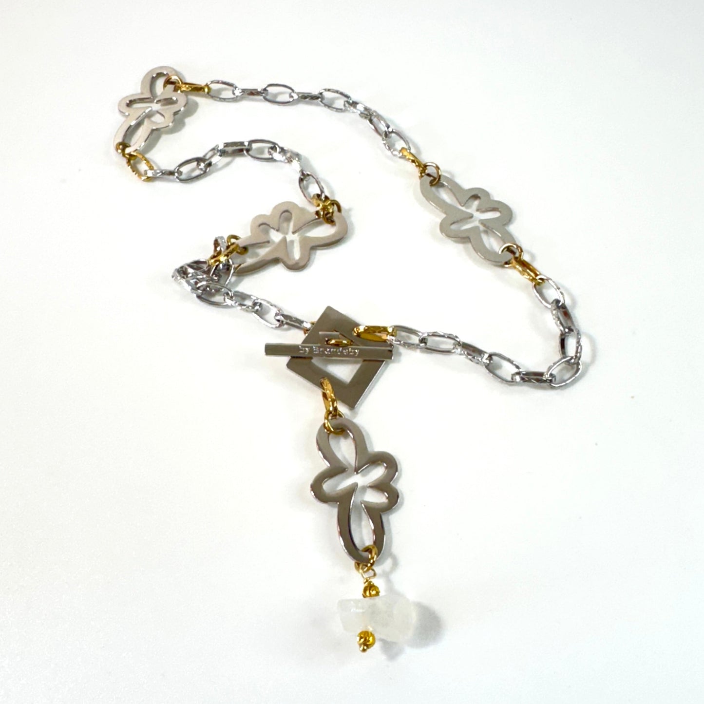 Halsband med äkta rå bergkristall, silverfärgad kedja, egendesignade blommor och guldringar i 18K PVD. Handgjort i rostfritt stål med sterling silver-pläterade detaljer. Ett unikt statementhalsband från Design by Brandeby.