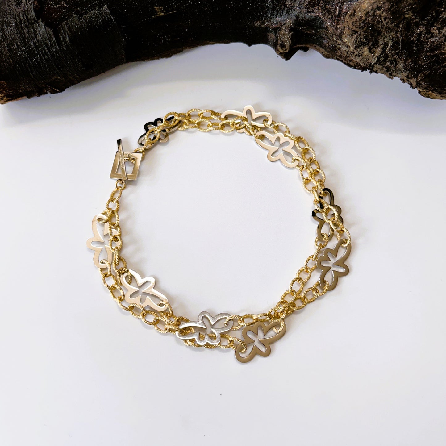 lyxigt halsband i guld och silver med blommor och guldkedja.