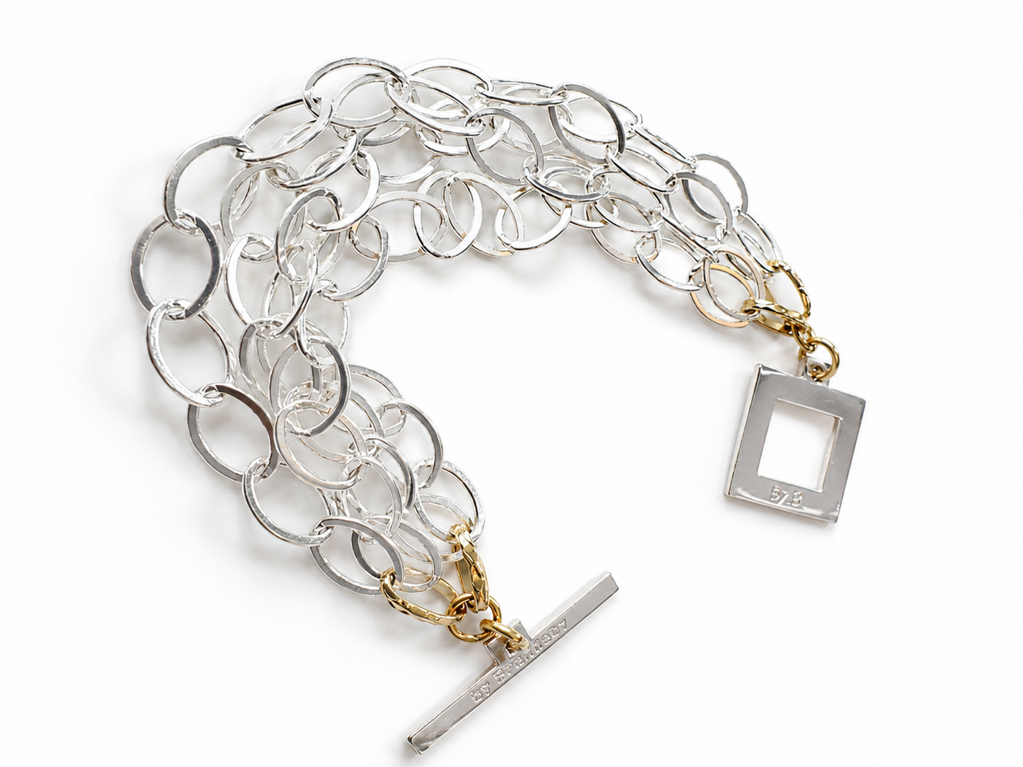 Elegant armband med sammanlänkade ringar i silverton och gulddetaljer. Tidlös design från Design by Brandeby som passar både vardag och fest.