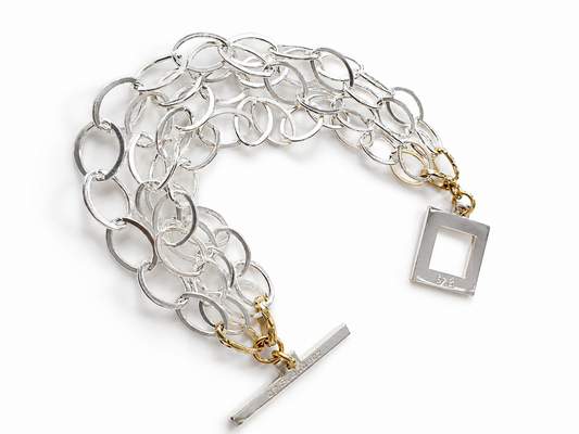 Elegant armband med sammanlänkade ringar i silverton och gulddetaljer. Tidlös design från Design by Brandeby som passar både vardag och fest.