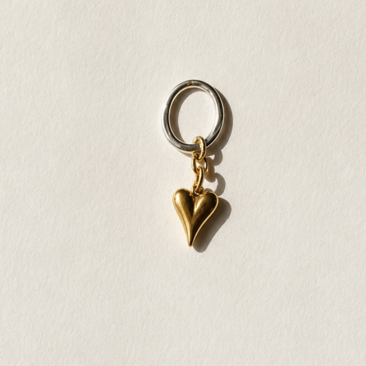 Elegant hjärthänge med massivt guldhjärta i rostfritt stål med 18K guld PVD-beläggning och egendesignad silvercirkel med sterling silver-pläterade detaljer. Ett tidlöst smycke från Design by Brandeby.