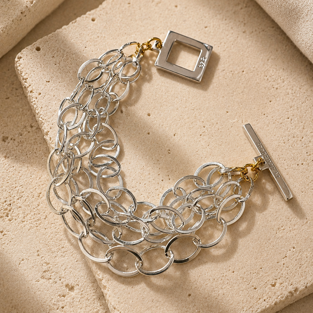 Elegant armband med sammanlänkade ringar i silverton och gulddetaljer. Tidlös design från Design by Brandeby som passar både vardag och fest.