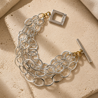 Elegant armband med sammanlänkade ringar i silverton och gulddetaljer. Tidlös design från Design by Brandeby som passar både vardag och fest.