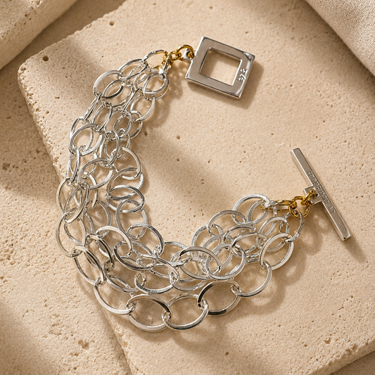 Elegant armband med sammanlänkade ringar i silverton och gulddetaljer. Tidlös design från Design by Brandeby som passar både vardag och fest.