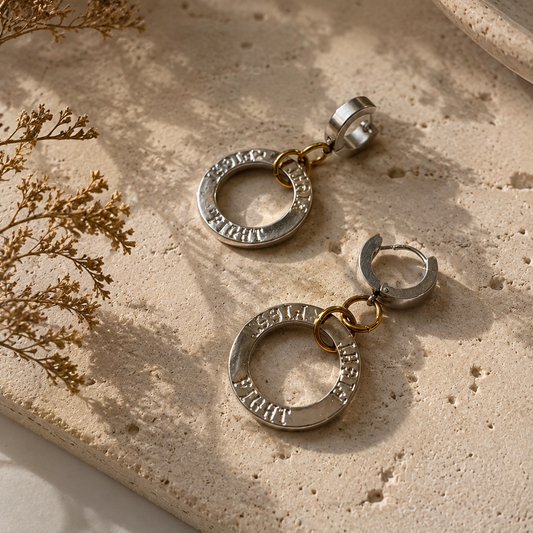 Fight Circle Örhängen med kirurgiska stift, silverfärgade ringar och detaljer i 18K guld PVD. Handgjorda örhängen med budskapet "Fight" från Design by Brandeby.