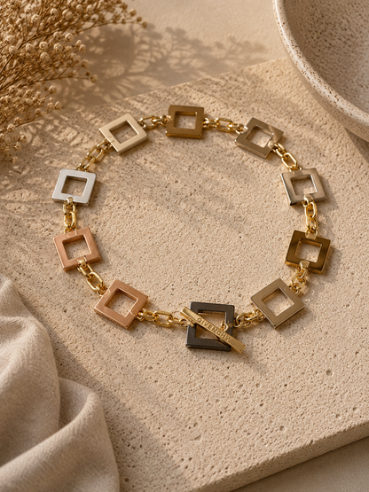 Infinity Square Halsband från Design by Brandeby med egendesignade fyrkanter i rostfritt stål med sterling silver-pläterade detaljer och texturerade guldringar i 18K PVD.