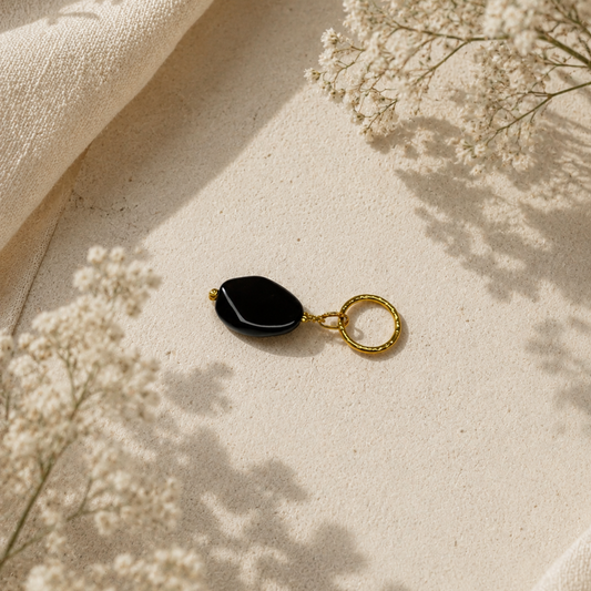 Elegant hänge med äkta svart agat och tunn guldring i rostfritt stål med 18K PVD-plätering. Ett stilrent och tidlöst smycke som passar både vardag och fest. Handgjort av Design by Brandeby.