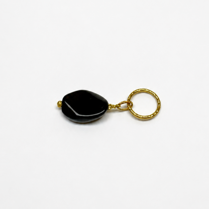 Elegant hänge med äkta svart agat och tunn guldring i rostfritt stål med 18K PVD-plätering. Ett stilrent och tidlöst smycke som passar både vardag och fest. Handgjort av Design by Brandeby.