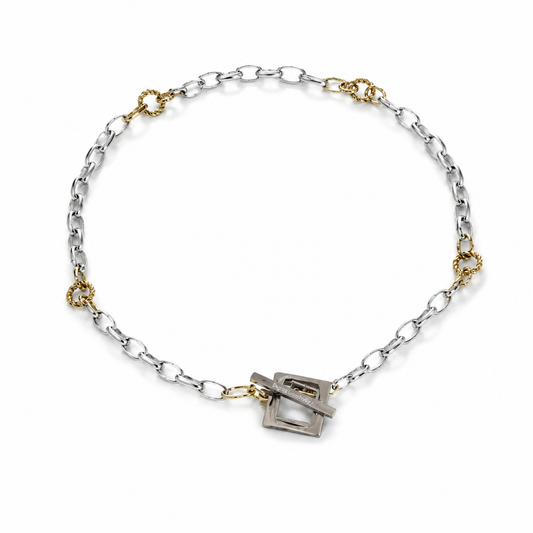 Elegant kedjehalsband i silver och guld med handgjord texturerad kedja, egendesignat lås och 18K guld PVD-belagda detaljer. Ett modernt och tidlöst halsband för både vardag och fest. Design by Brandeby.
