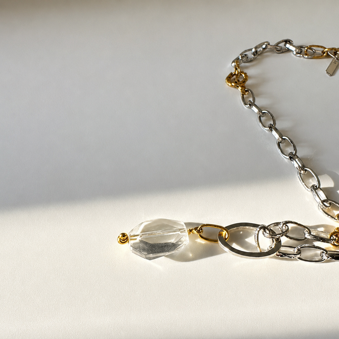 Elegant hänge med äkta bergkristall, fasade kanter och egendesignad cirkel i rostfritt stål med sterling silver-pläterade detaljer. Gulddetaljer i rostfritt stål med 18K guld PVD-beläggning. Handgjort av Design by Brandeby.