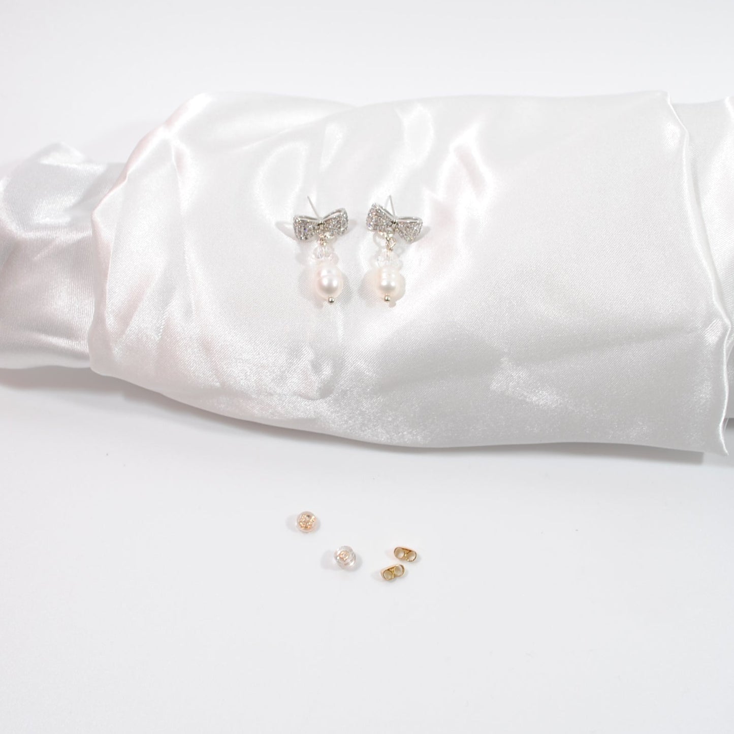 Eleganta Bow Pearls Silver Örhängen i silver med strass fylld rosett, äkta sötvattenpärla och bergkristall. Handgjorda i Sverige. Limited edition.