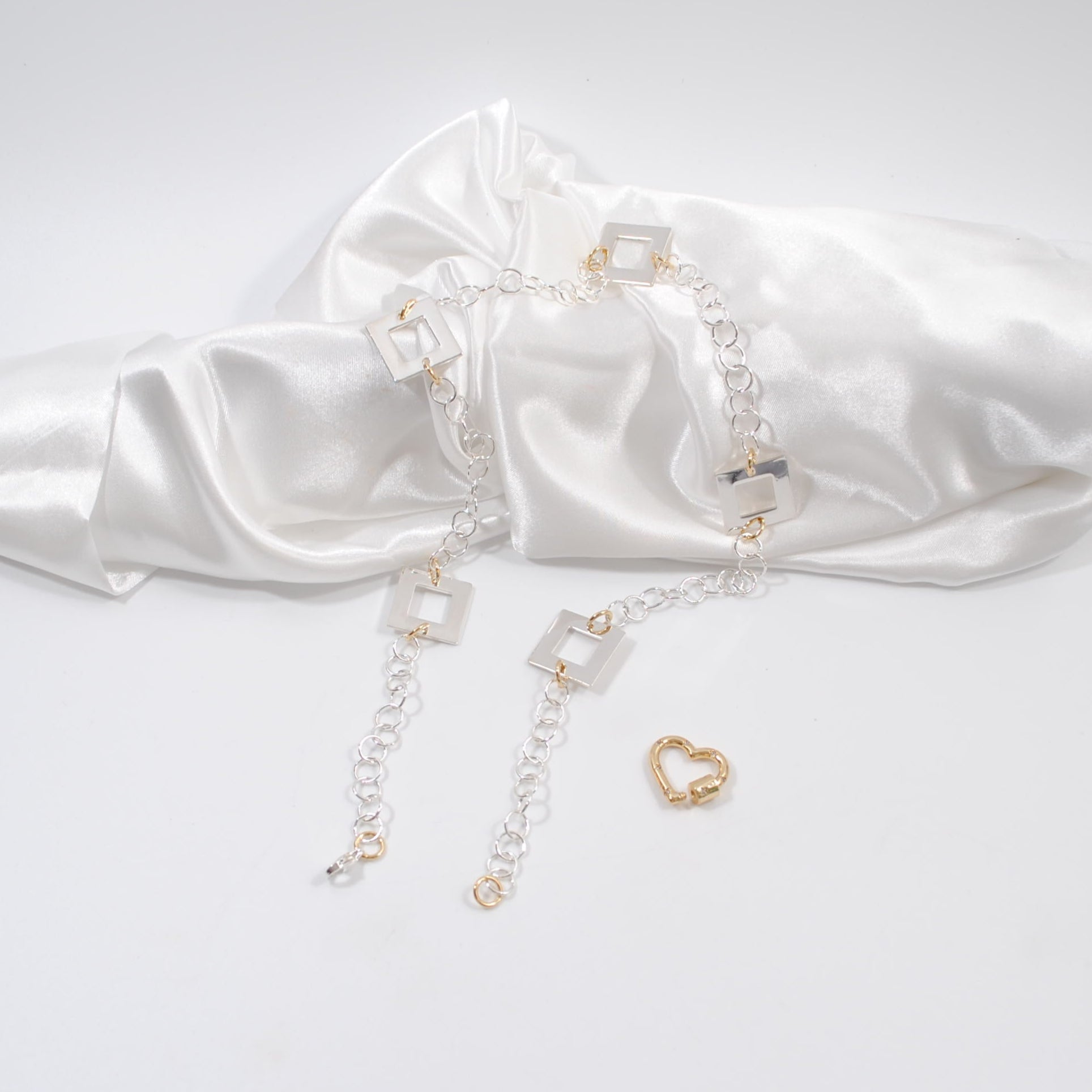 enkelt elegant lyxigt halsband med fyrkanter kedja i silver och ett guld lås som hjärta design by brandeby