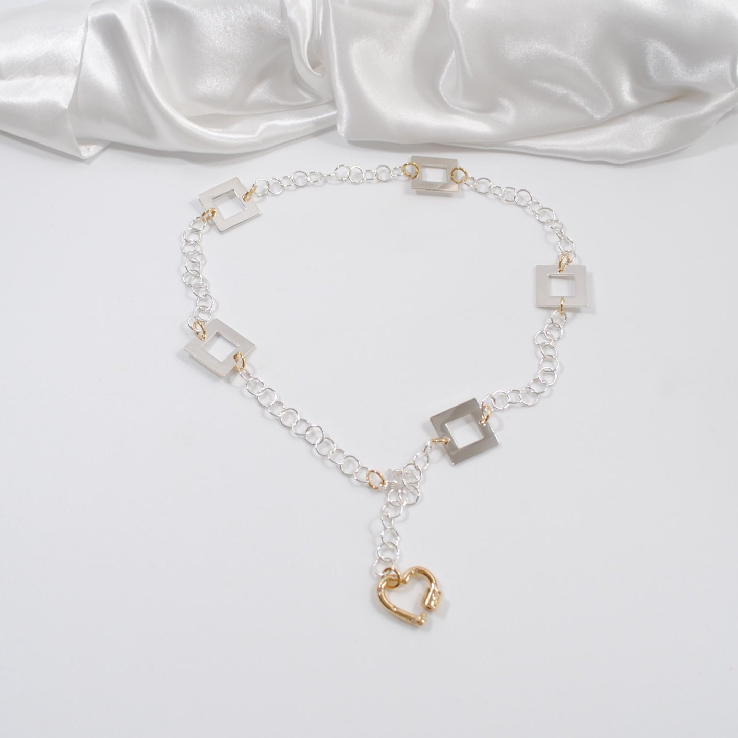 handgjort fint elegant halsband med silverkedja och silver fyrkanter med ett hjärta som guld lås design by brandeby