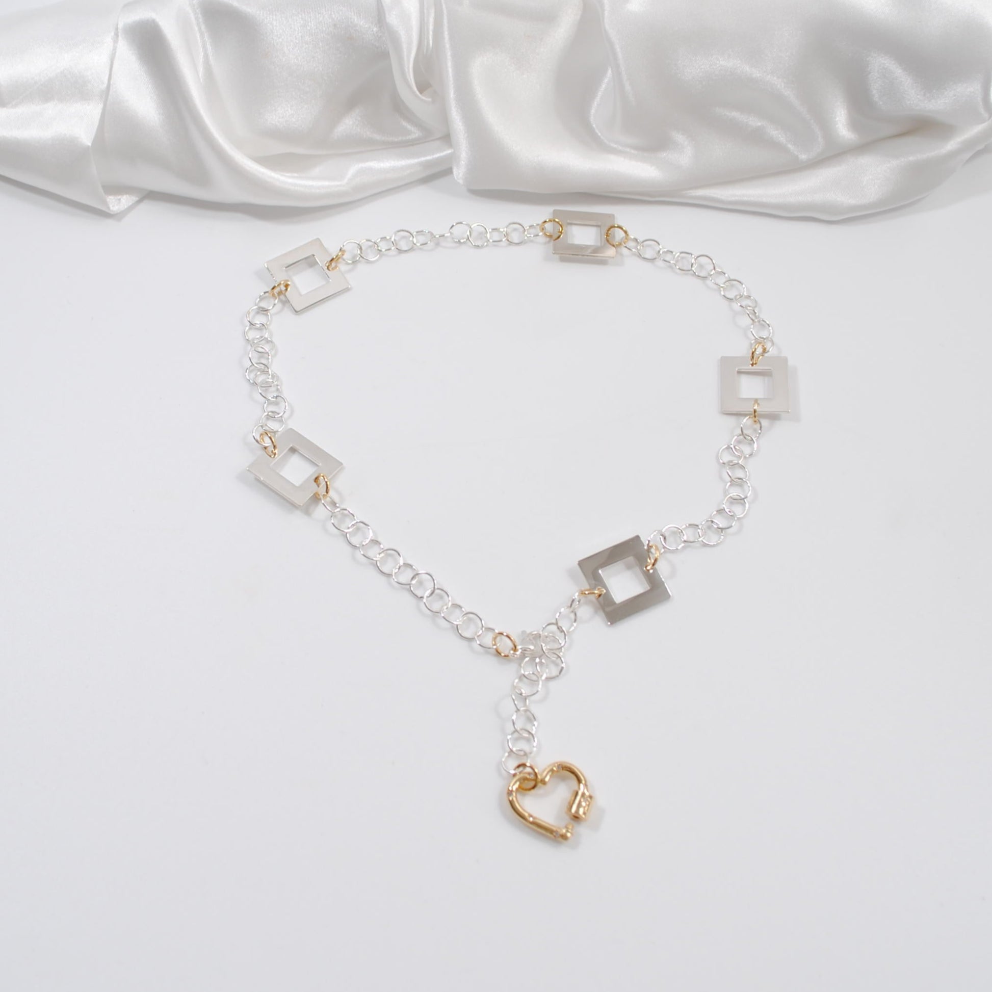 handgjort fint elegant halsband med silverkedja och silver fyrkanter med ett hjärta som guld lås design by brandeby