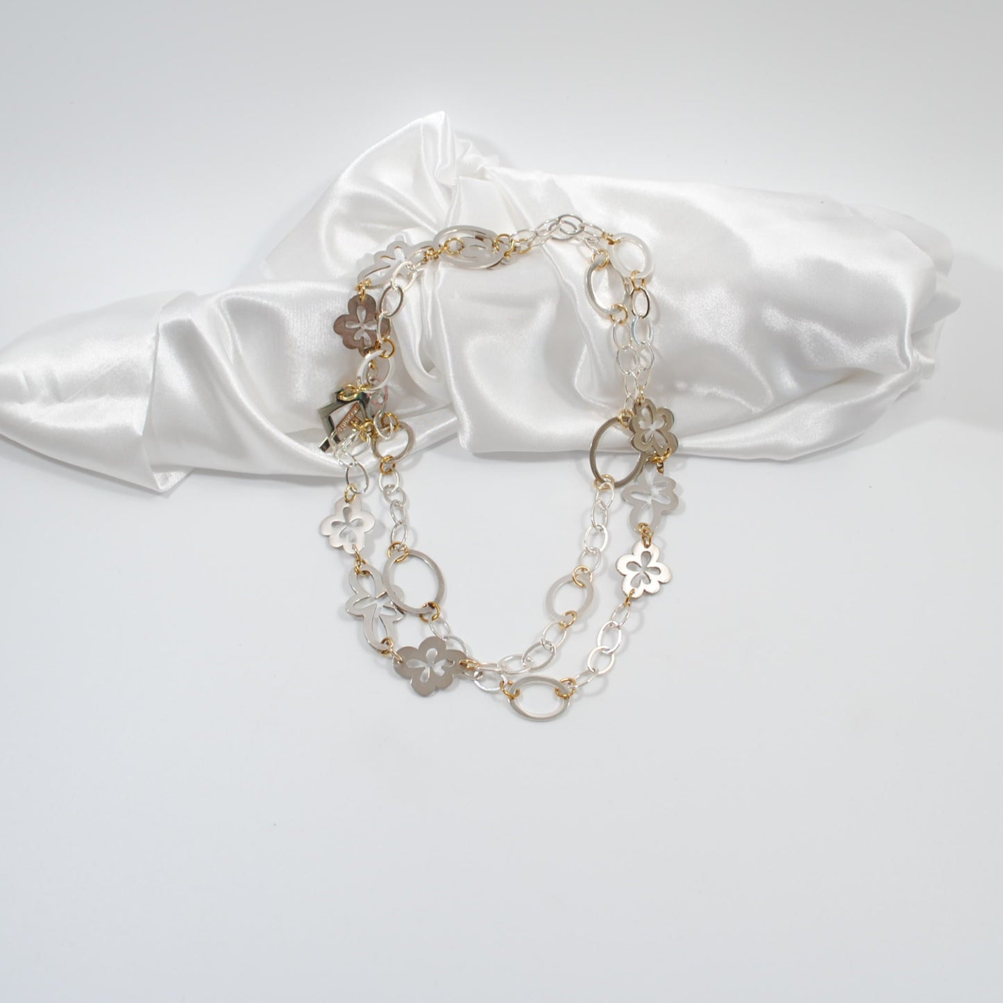 unikt långt handgjort halsband med egendesingade delar som blommor cirkar och silver kedja design by brandeby