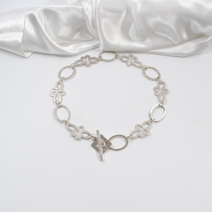 ett kort halsband i silver med cirklar och blommor egendesignat design by brandeby