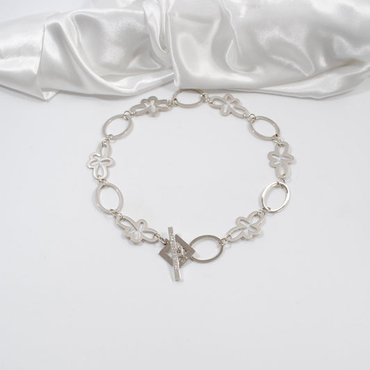 ett kort halsband i silver med cirklar och blommor egendesignat design by brandeby