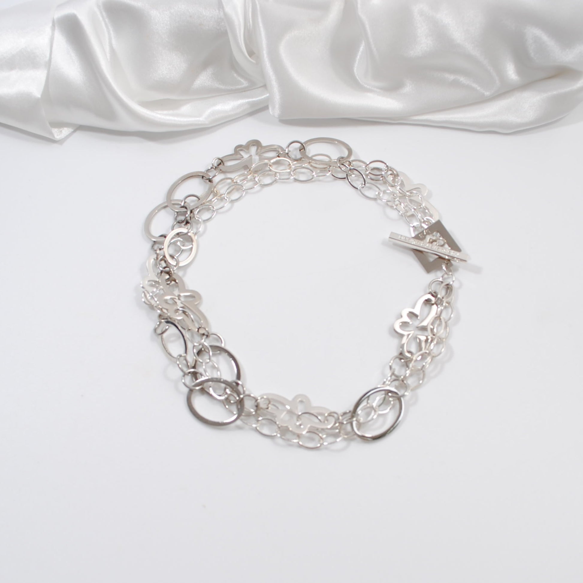 silver halsband i tre rader med cirklar och blommor design by brandeby