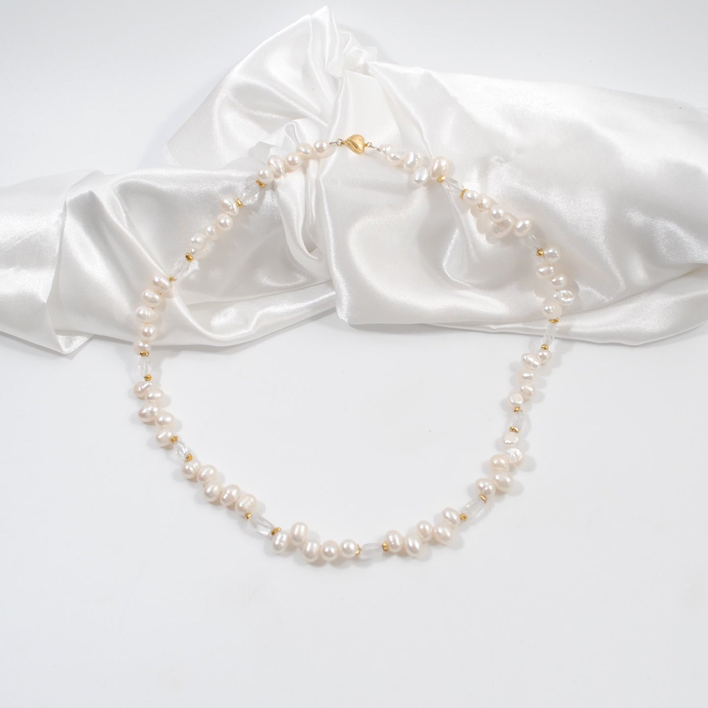 lyxigt handgjort elegant kort sötvattenspärlhalsband med sterling silver guldpläterat med ett hjärt lås i guld design by brandeby