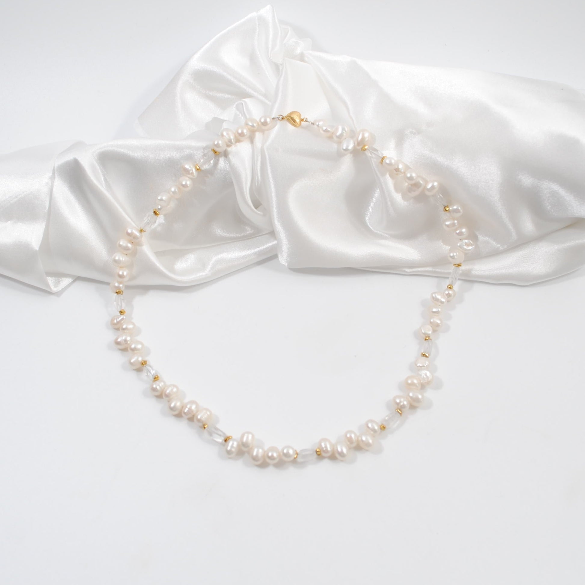 lyxigt handgjort elegant kort sötvattenspärlhalsband med sterling silver guldpläterat med ett hjärt lås i guld design by brandeby