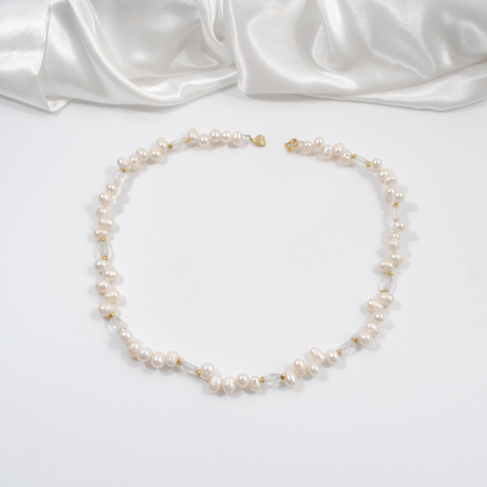 äkta svenskt hantverk kort halsband med vita sötvattens pärlor och sterling silver hjärtlås bergkristaller design by brandeby