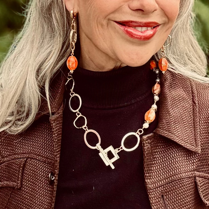 Mrs Sigetty Örhängen är eleganta örhängen där äkta orange imperial jasper möter dubbla guldringar och 18 karats guld. De vackra ädelstenarna i varma orange toner skapar ett unikt och livfullt uttryck. Ett statement-smycke som utstrålar både elegans och lyx.