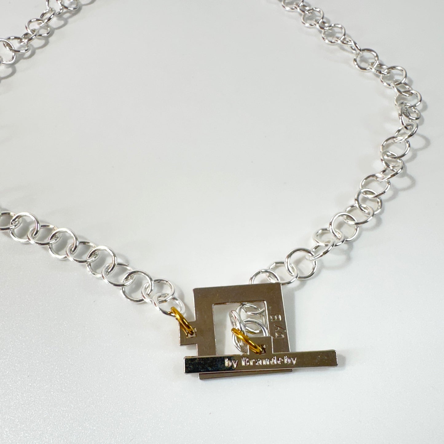 Elegant Silver Rollo Halsband från Design by Brandeby. Stilren silverfärgad rollokedja med egendesignat lås i rostfritt stål med sterling silver-pläterade detaljer. Handgjort i Sverige.