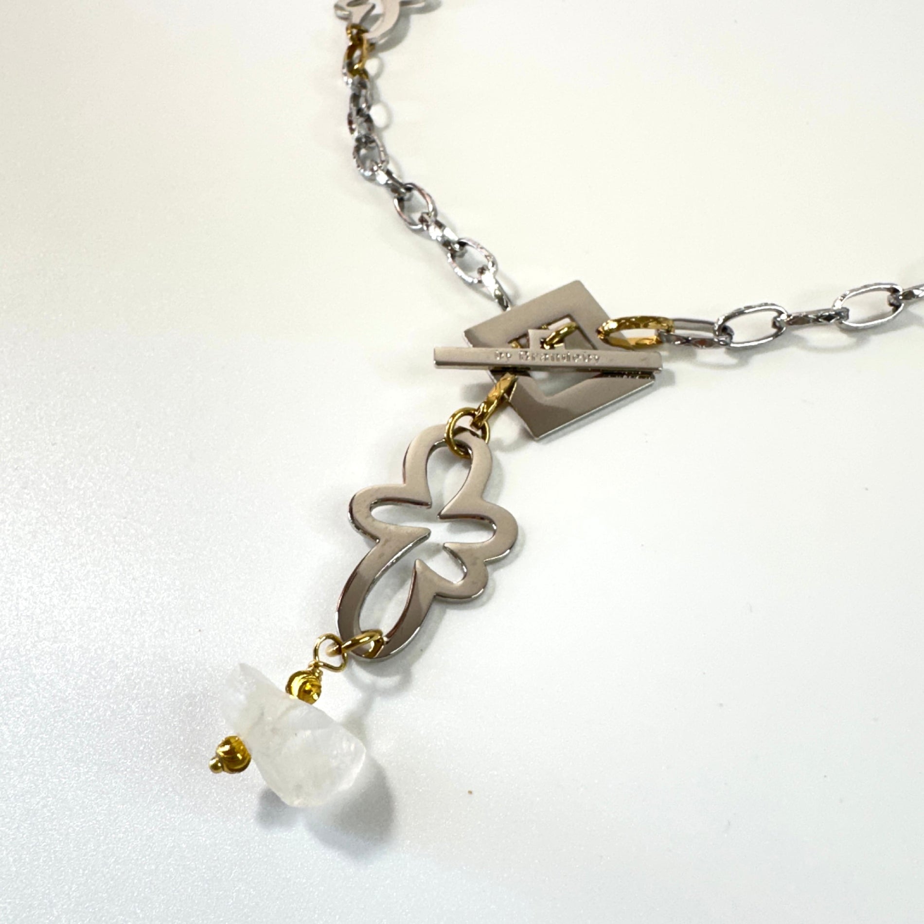 Halsband med äkta rå bergkristall, silverfärgad kedja, egendesignade blommor och guldringar i 18K PVD. Handgjort i rostfritt stål med sterling silver-pläterade detaljer. Ett unikt statementhalsband från Design by Brandeby.