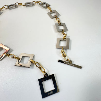 Infinity Square Halsband från Design by Brandeby med egendesignade fyrkanter i rostfritt stål med sterling silver-pläterade detaljer och texturerade guldringar i 18K PVD.
