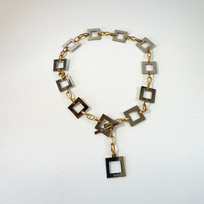Infinity Square Halsband från Design by Brandeby med egendesignade fyrkanter i rostfritt stål med sterling silver-pläterade detaljer och texturerade guldringar i 18K PVD.