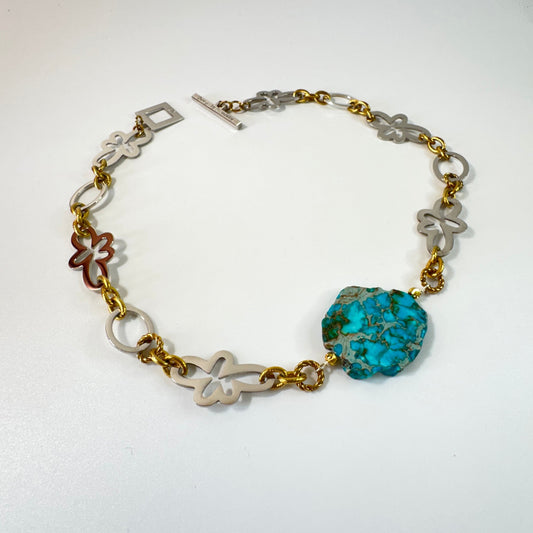 Statementhalsband med turkos Imperial Jasper, egendesignade blommor och cirklar. Handgjort i rostfritt stål med sterling silver-pläterade detaljer och 18K PVD-guldringar. 53 cm. Design by Brandeby.