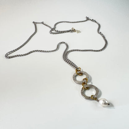 Flexibelt halsband med två cirklar med texten Fight, äkta vit sötvattenspärla och gulddetaljer i 18K PVD. Bär det kort eller långt för olika uttryck. Handgjort av Design by Brandeby.