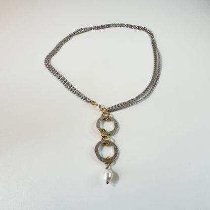 Flexibelt halsband med två cirklar med texten Fight, äkta vit sötvattenspärla och gulddetaljer i 18K PVD. Bär det kort eller långt för olika uttryck. Handgjort av Design by Brandeby.