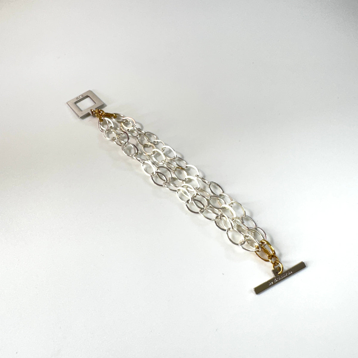 Elegant armband med sammanlänkade ringar i silverton och gulddetaljer. Tidlös design från Design by Brandeby som passar både vardag och fest.