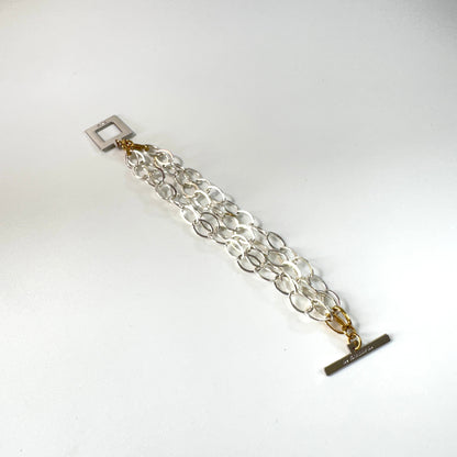 Elegant armband med sammanlänkade ringar i silverton och gulddetaljer. Tidlös design från Design by Brandeby som passar både vardag och fest.