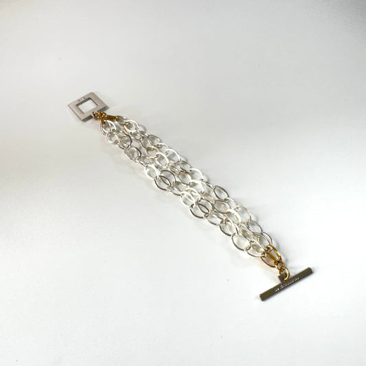 Elegant armband med sammanlänkade ringar i silverton och gulddetaljer. Tidlös design från Design by Brandeby som passar både vardag och fest.