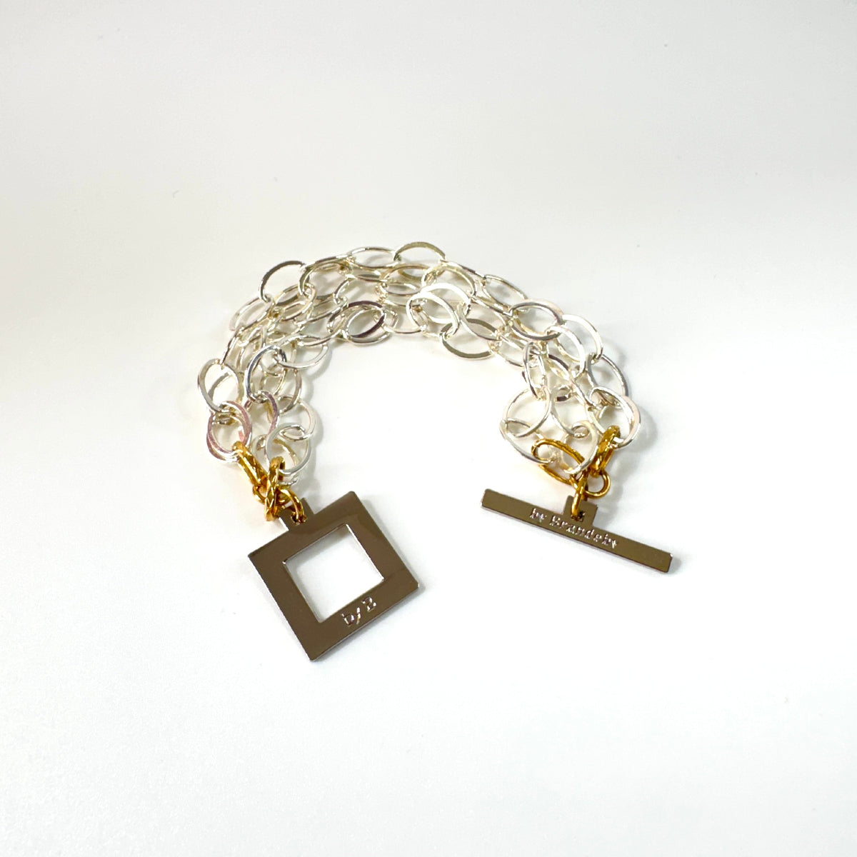 Elegant armband med sammanlänkade ringar i silverton och gulddetaljer. Tidlös design från Design by Brandeby som passar både vardag och fest.