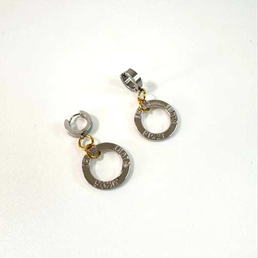 Fight Circle Örhängen med kirurgiska stift, silverfärgade ringar och detaljer i 18K guld PVD. Handgjorda örhängen med budskapet "Fight" från Design by Brandeby.