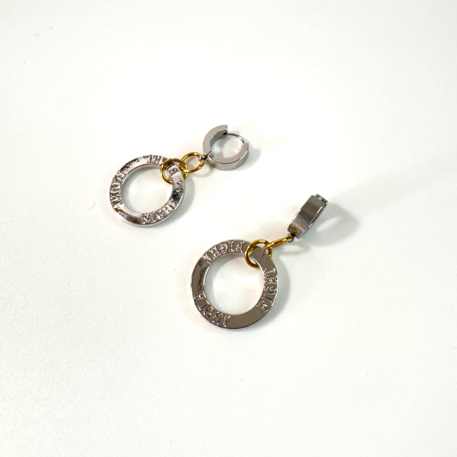 Fight Circle Örhängen med kirurgiska stift, silverfärgade ringar och detaljer i 18K guld PVD. Handgjorda örhängen med budskapet "Fight" från Design by Brandeby.