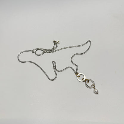 Flexibelt halsband med två cirklar med texten Fight, äkta vit sötvattenspärla och gulddetaljer i 18K PVD. Bär det kort eller långt för olika uttryck. Handgjort av Design by Brandeby.