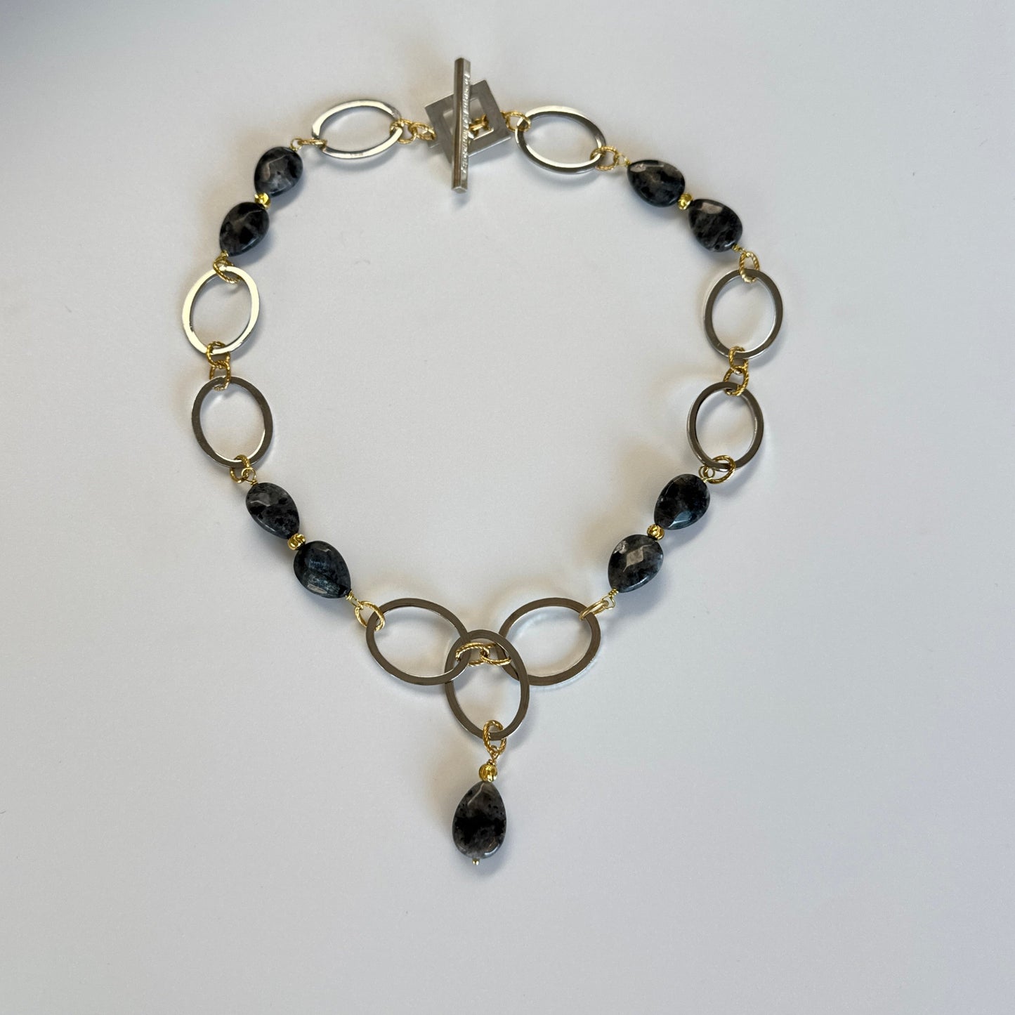  Elegant halsband med äkta labradorit, egendesignade cirklar i rostfritt stål med sterling silver-pläterade detaljer och texturerade guldringar i 18K PVD. Bär med eller utan den hängande cirkeln för olika uttryck. Längd 53 cm. Design by Brandeby.
