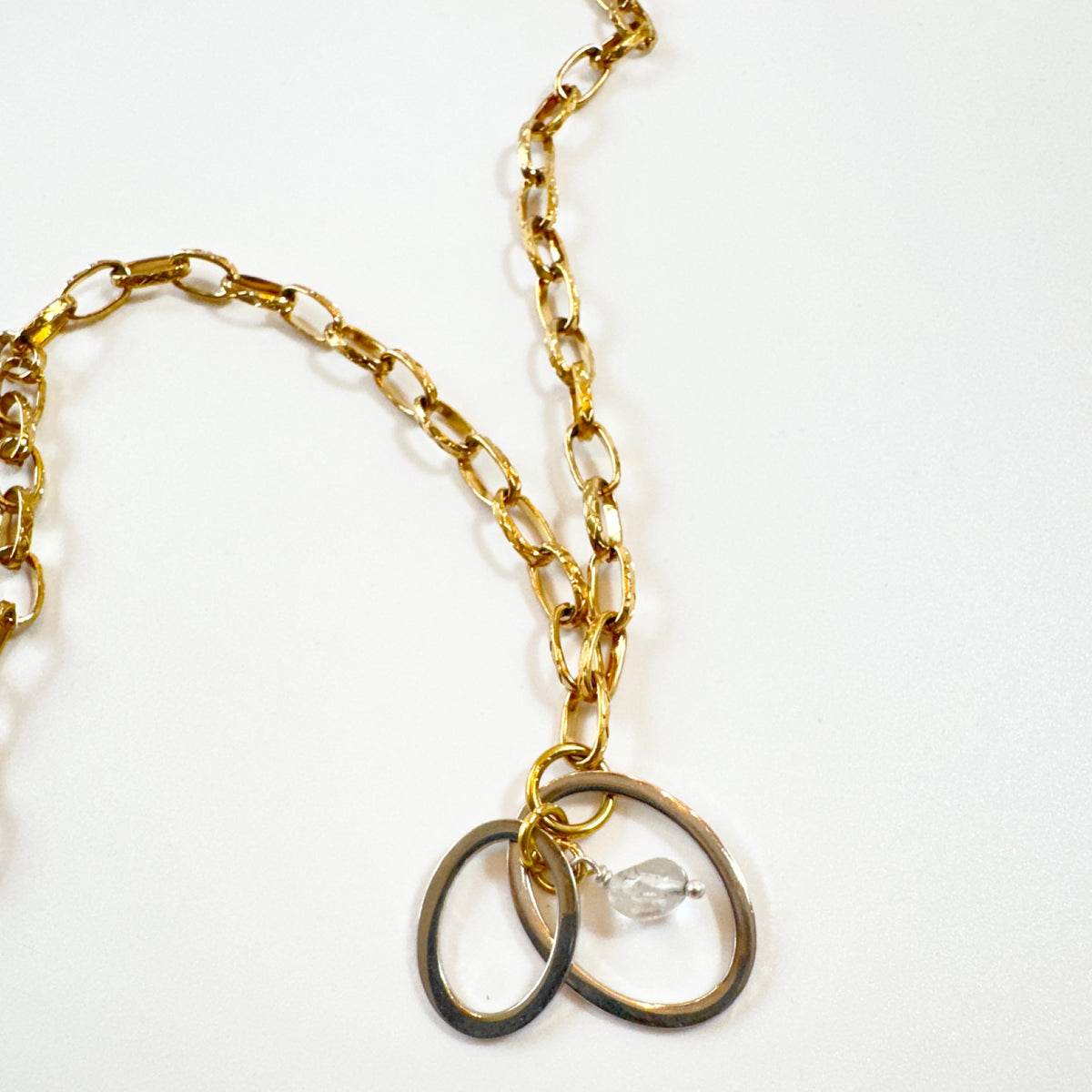Handgjort halsband med äkta bergkristall och två cirklar i rostfritt. Justerbar kedja i rostfritt stål i 18K guld pvd. Designat av Sussie Brandeby i Helsingborg.