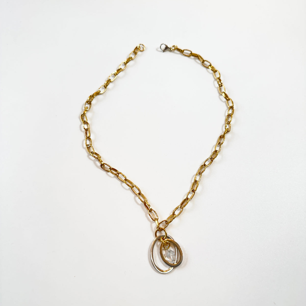 Handgjort halsband med äkta bergkristall och två cirklar i rostfritt. Justerbar kedja i rostfritt stål i 18K guld pvd. Designat av Sussie Brandeby i Helsingborg.