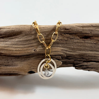 Handgjort halsband med äkta bergkristall och två cirklar i rostfritt. Justerbar kedja i rostfritt stål i 18K guld pvd. Designat av Sussie Brandeby i Helsingborg.